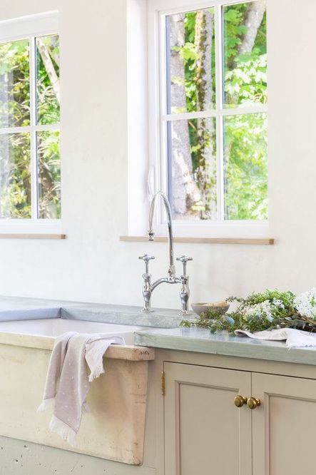 The large farmhouse sink with nickel faucet fixture is placed below the windows, providing a stunning view of the outdoors. (Photography by Alyssa Rosenheck)