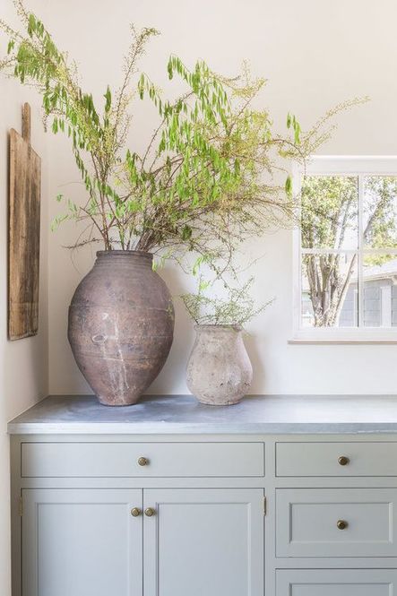A corner of the kitchen is simply styled using weathered pottery and a rectangular cutting board. (Photography by Alyssa Rosenheck)