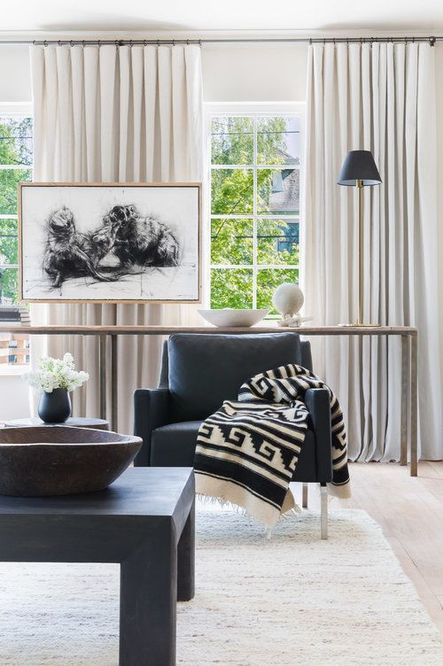 Vertical elements like this black shaded lamp and tall, skinny windows draw the eyes upward, exaggerating the illusion of a larger space. (Photography by Alyssa Rosenheck)