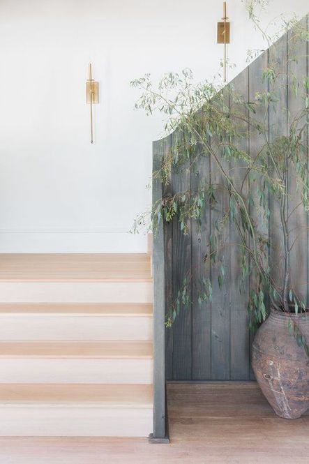 Thin candle sconces, antique ceramic vase, &amp; vertical fence-like railing create a chic, yet rustic entry area. (Photography by Alyssa Rosenheck)