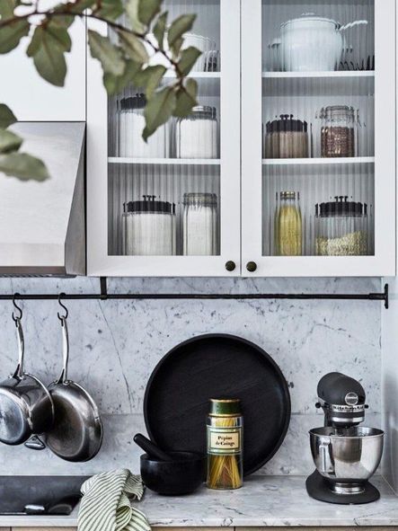 Fluting is also used in the these cabinet doors to partially expose the contents behind, while adding rich texture to the kitchenβs prep space.