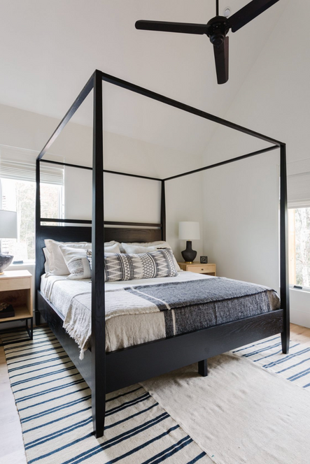 A third bedroom uses layering rugs and pillows to create texture.