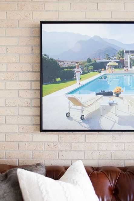 Poolside Glamour print by Slim Aarons. We reserved using saturated color in the rest of the space to really let this piece shine above the leather Chester Sofa.