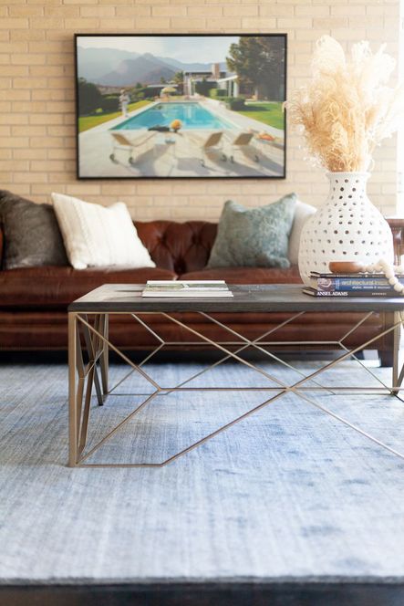 At the rooms center, clean lines &amp; geometric shapes from the Theodore Coffee Table balance the natural textures from the porous vase and bone styling beads. The mixing of these modern and natural elements bring bring a sophisticated eclecticism into the space.